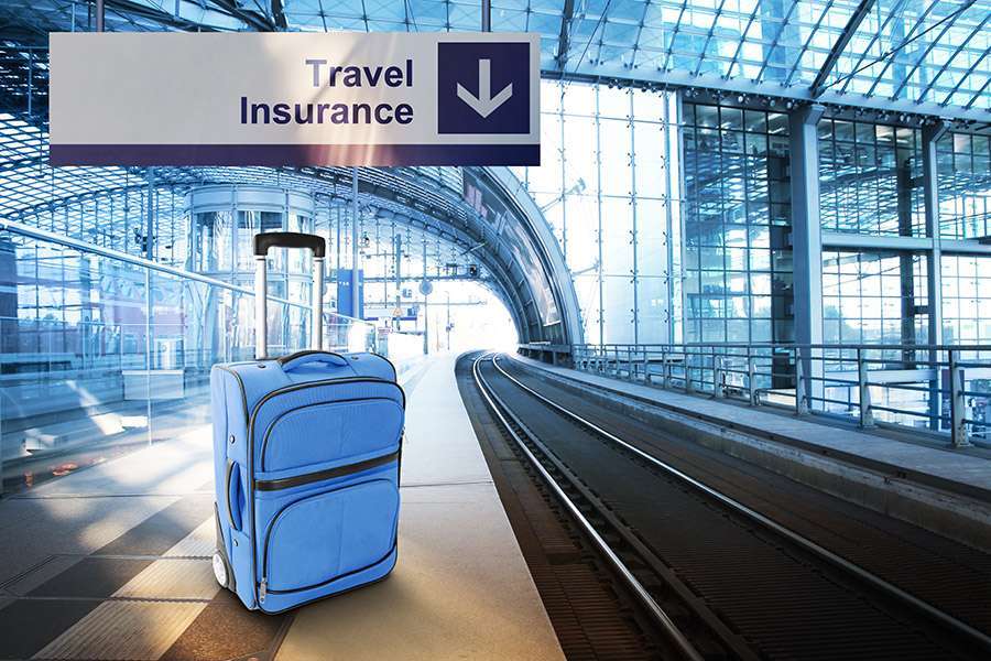 Luggage at airport under travel insurance sign