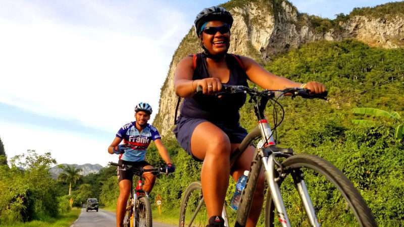 Two cyclists ride through Vinales