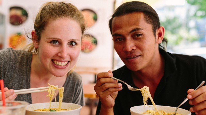 A solo traveller eating laksa in Malaysia
