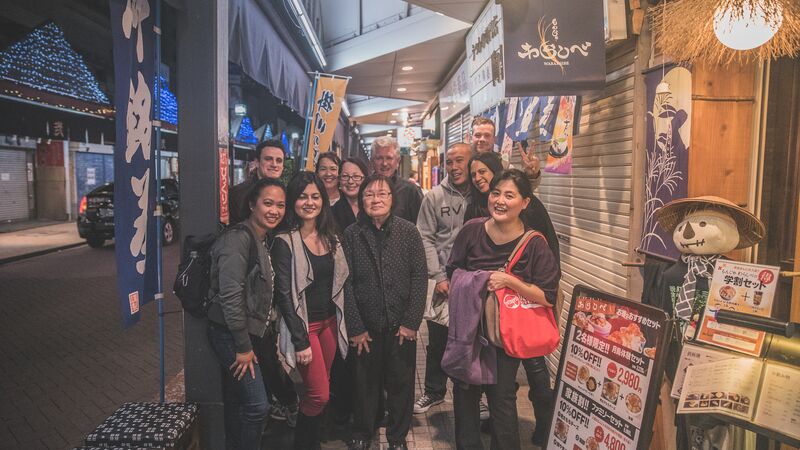 A group of people standing on a street in Tokyo